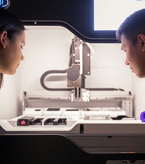 two people looking at a microscope