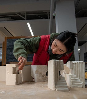 architecture student with building model