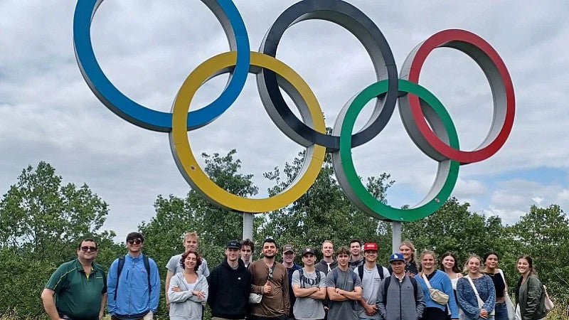 Group of UO students standing in front of the Olympic rings
