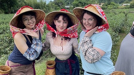 Group of students posing in Taiwan, wearing traditional hats and scarves
