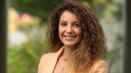 Headshot of Hadil Abuhmaid standing in front of greenery