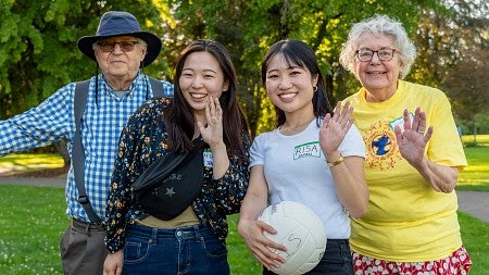 Two international students posing with their homestay hosts