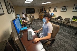 study at computer wearing face mask